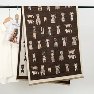 Gemütlicher brauner Kaschierschal mit süßem Katzenprint, warmes Accessoire im Detail.