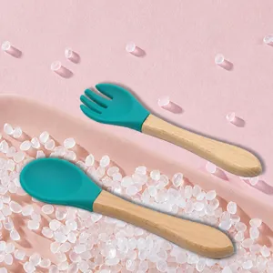 Baby silicone spoon and fork set with wooden handle for infant feeding and food training safe use.