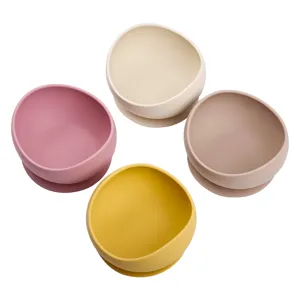 Detailed view of four colorful silicone baby suction bowls in pink, beige, brown, and yellow.