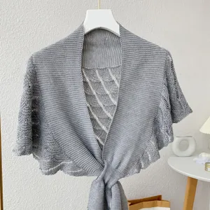 Grey knitted bolero shawl detail, hollow-out texture design, elegant neck and shoulder cover.