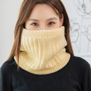 Close-up of thick yellow knitted neck warmer, cable knit thermal winter accessory.