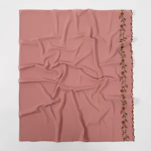 Detailed view of the pink floral embroidered scarf, showing delicate scalloped lace edge.