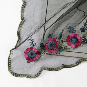 Detailed view of sheer black mesh scarf featuring colorful floral embroidery and delicate lace trim.
