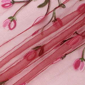 Gros plan sur les détails du foulard en nylon transparent brodé de motifs floraux fins.