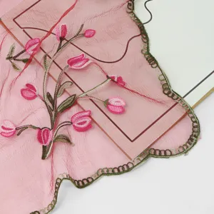 Détail exquis d'écharpe brodée rose avec motifs de tulipes délicates et bordure en dentelle.