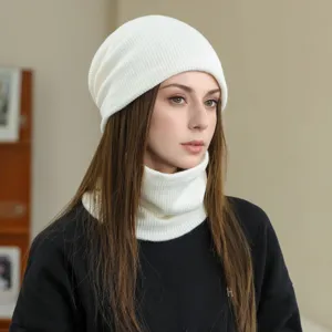 Close-up detail of the cozy white knitted beanie hat and matching neck warmer set.