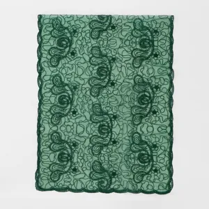 Green lace scarf detail, hollow embroidered floral pattern, elegant women shawl fabric.