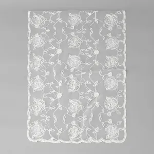 White floral embroidered lace scarf detail showing delicate rose patterns on mesh fabric.