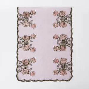Detailed view of the light pink embroidered floral scarf, showcasing delicate rose patterns.