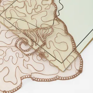 Close-up detail of lightweight sheer nylon embroidered lace shawl scarf with intricate brown patterns.