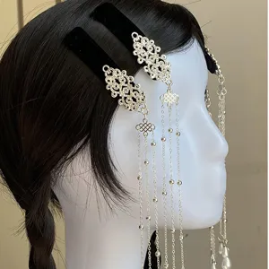 Close-up detail of Chinese style black velvet hair clip with silver chains and pearls.