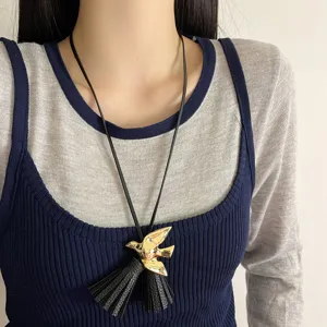 Elegante schwarze Lederkordel Halskette mit goldfarbenem Vogel Anhänger und Fransen Quasten.