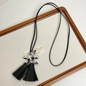 Schwarze Lederkordel Halskette mit silbernem Vogel Anhänger und Quasten, stilvoller Schmuck.