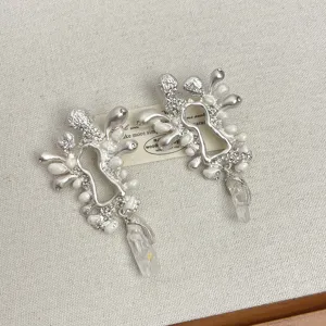 Vue détaillée de boucles d'oreilles rétro avant-gardistes avec perles et cristaux.