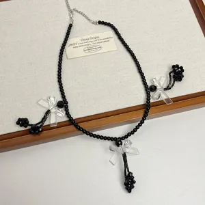 Vista dettagliata della collana girocollo perline nere fiocco Y2K, accessorio stile punk.
