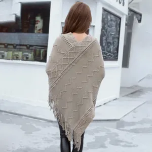 Back view detail of a stylish casual knitted poncho with fringe and geometric pattern.