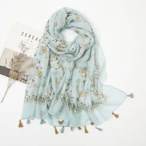 Detailed view of the light blue floral printed scarf highlighting soft fabric and delicate tassels.