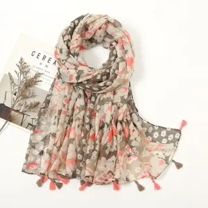 Detailed view of floral print tassel scarf, soft cotton linen texture for spring and summer.
