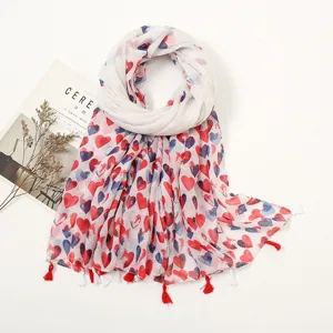 Detailed close-up view of a soft cotton-linen scarf featuring vibrant red and blue heart patterns.