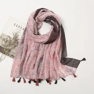 Detailed view of the floral butterfly print scarf with delicate tassels, close-up fabric texture.