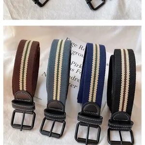 Canvas belt detail showing four classic colors with metal pin buckles and woven striped pattern.
