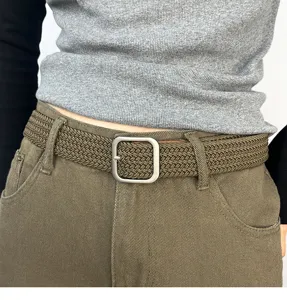 Woven belt detail showing texture and square metal buckle worn on trousers. Perfect style.