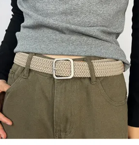 Detail shot of a casual khaki woven elastic belt featuring a modern silver square metal buckle.