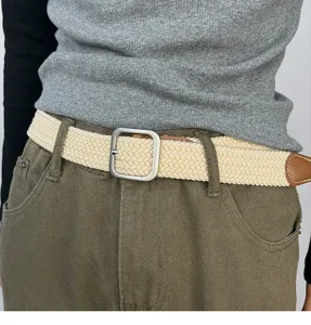 Close-up view of a stylish woven belt featuring a metal square buckle and leather tip.
