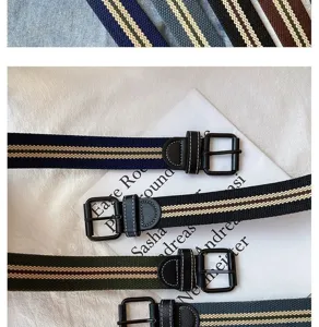 Detailed shot of striped canvas belts featuring leather details and black buckles.