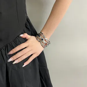 Brazalete rígido geométrico plateado vista detallada, joya de brazo moderna y elegante.