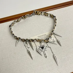 Nahaufnahme der Y2K Leo-Muster Leder Choker Halskette mit Metallkreuz und Nietenhängern.