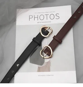 Heart buckle slim leather belt detail, black and brown stylish waistband for casual jeans.