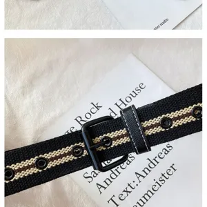 Canvas belt detail featuring striped pattern, metal eyelets, and classic black square buckle.