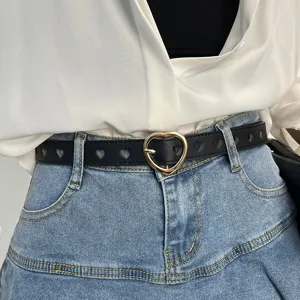 Black leather belt with heart buckle and cutouts worn with denim skirt for women fashion daily