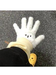 Gros plan de gants d'hiver mignons en peluche tactile blanche avec un joli visage d'ours.