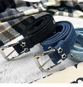 Close-up detail of stylish denim belts featuring metallic star studs and pin buckles for women.