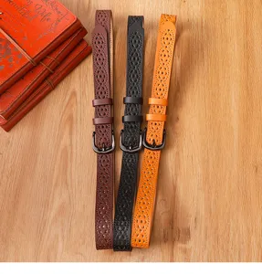 Detailed view of women's hollow out leather belt with pin buckle, stylish design for jeans.