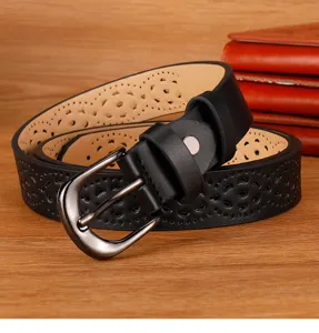 Close-up of a women's black leather belt with stylish hollow-out patterns and metal buckle.