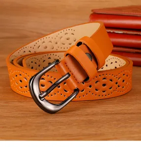 Women's orange perforated leather belt with stylish pin buckle, casual floral cutout design.