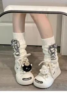 Weisse Strick Slouch Socken Detailansicht mit verspielten Schleifen und Freizeitschuhen.