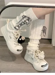 Weiße gestrickte Stulpen mit schwarz-weißen Karobändern und klobigen Sneakers für stilvolle JK-Outfits.