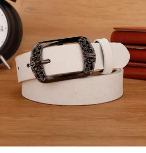 Detail of white leather belt with embossed butterfly pattern and vintage metal pin buckle.