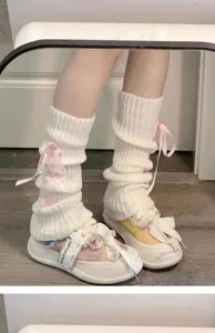 Weiße gestrickte Beinwärmer mit süßen rosa Schleifen, modische JK-Stil Schuhdetails.