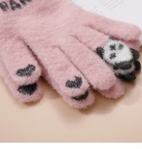 Gros plan détaillé de gants d'hiver en tricot rose avec un motif de panda et cœurs.