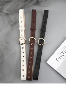Close-up detail shot of stylish womens heart cutout leather belts in white brown and black.