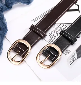 Close-up of women's fashion leather belts with gold oval buckles and contrast stitching details.