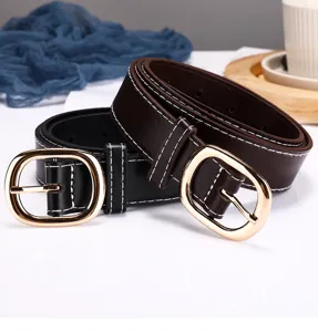 Detailed shot of women's leather belts with gold oval buckles and white stitching.