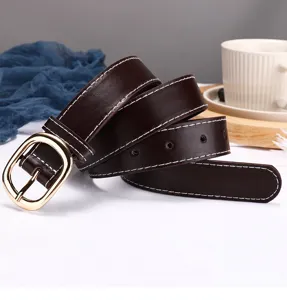 Brown leather women belt detail view with golden oval buckle and contrast white stitching.