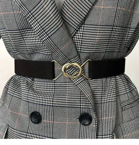 Primer plano de los detalles del cinturón elástico de mujer con elegante hebilla dorada.