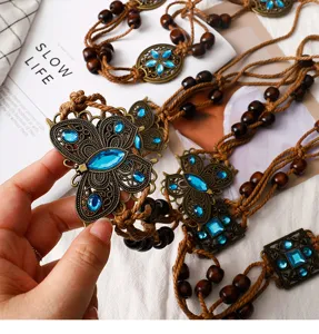 Detailed view of vintage bohemian butterfly waist chain with wood beads and blue stones.